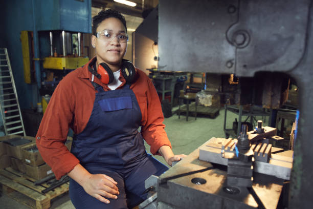 istock Female Worker Posing by Heavy Machinery 1192778696
