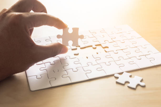 istock hands of man jigsaw puzzle connecting. 1192782345