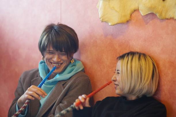 istock Two young men and women smoking a hookah 1192787860