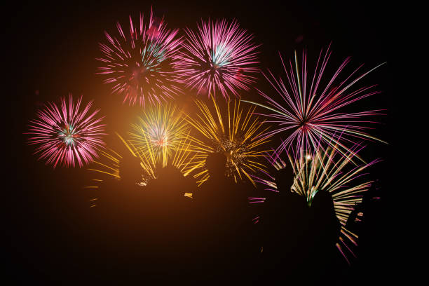 Crowd watching fireworks and celebration. Happy family sitting on floor and watching the fireworks Celebration at night on New Year and copy space - abstract holiday background. Crowd watching fireworks and celebration. Happy family sitting on floor and watching the fireworks Celebration at night on New Year and copy space - abstract holiday background. new year urban scene horizontal people stock pictures, royalty-free photos & images