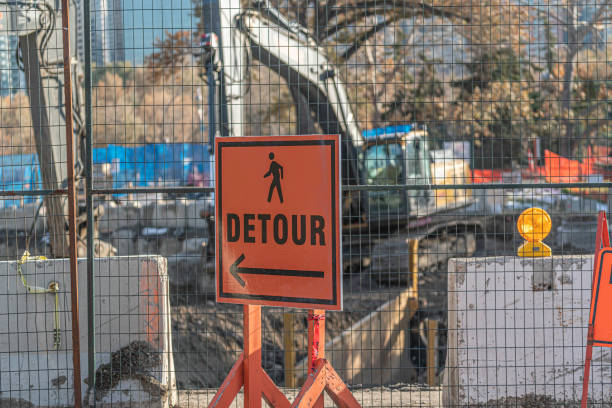 istock Orange square Detour sign on contruction site fence 1192801516