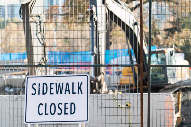 istock Sidewalk Closed Sign at construction site fence 1192802094
