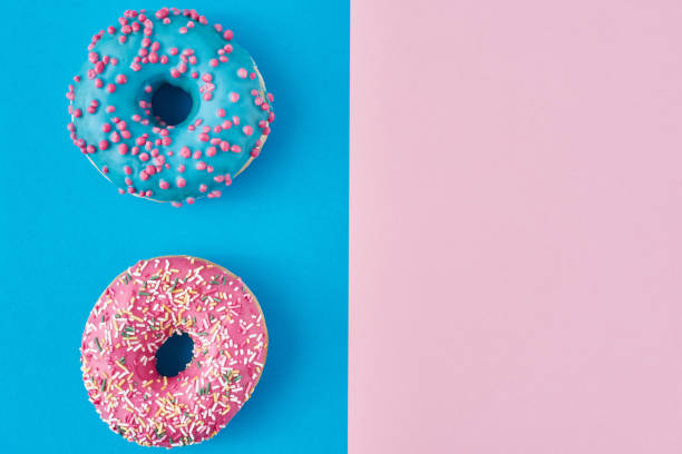 istock Two donuts on a pastel pink and blue background. Minimalism creative food composition. Flat lay style 1192802236