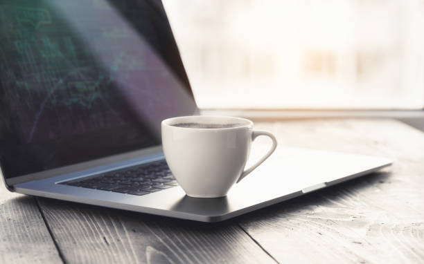 istock Cup Coffee On Home Office Workplace With Laptop And Graph 1192803570