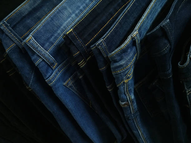 many models of jeans from different denim, texture, color hang on hangers stock photo