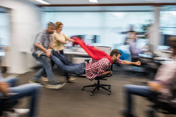 istock Group of playful colleagues having fun in blurred motion at casual office. 1192811114