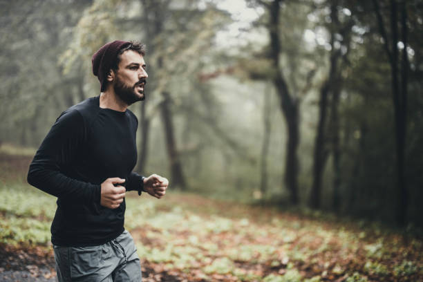 istock Determined athletic man running in autumn day at the park. 1192812983