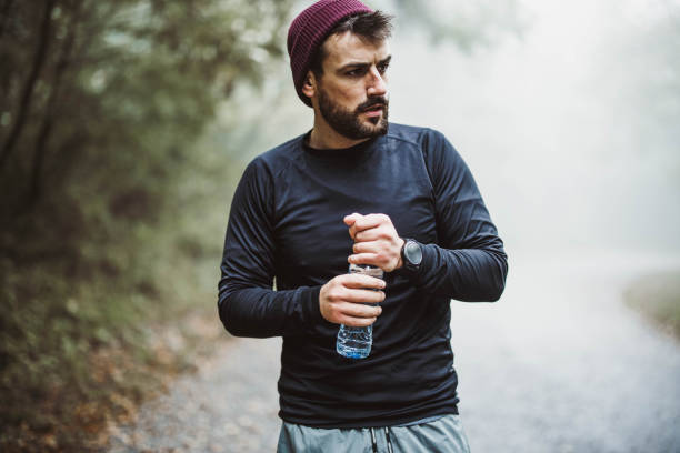 istock Young athletic man having a water break in nature. 1192814078