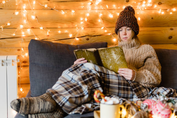 istock Reading book on cozy sofa in warm house. 1192815105
