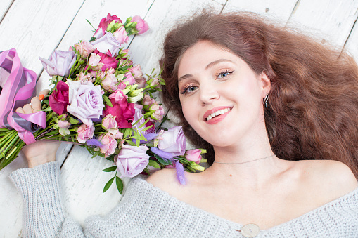 Portrait of a woman with flowers from above. girl with long hair with a bouquet.