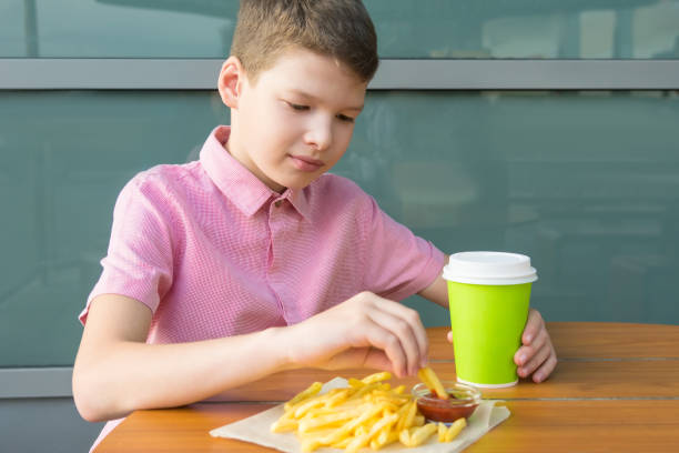 istock boy having lunch between classes at school french fries with ketchup 1192820685