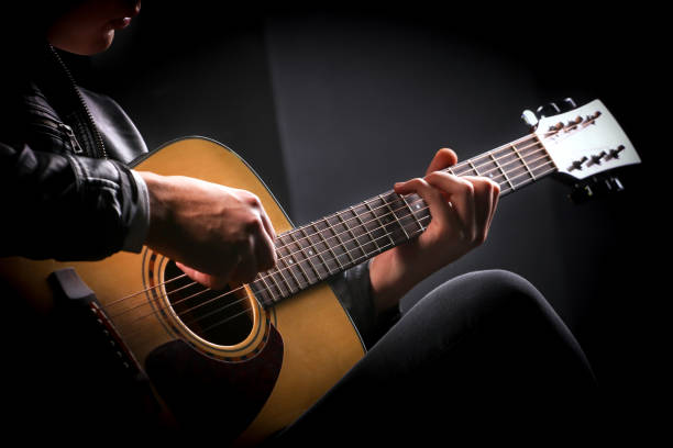istock Young men playing the guitar with black background 1192820997