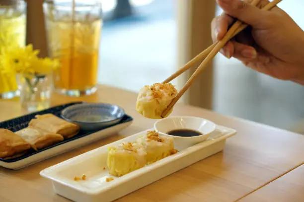 Photo of Dim Sum Recipe - Chinese shrimp dumplings topped with fried garlic, served with sour sauce.