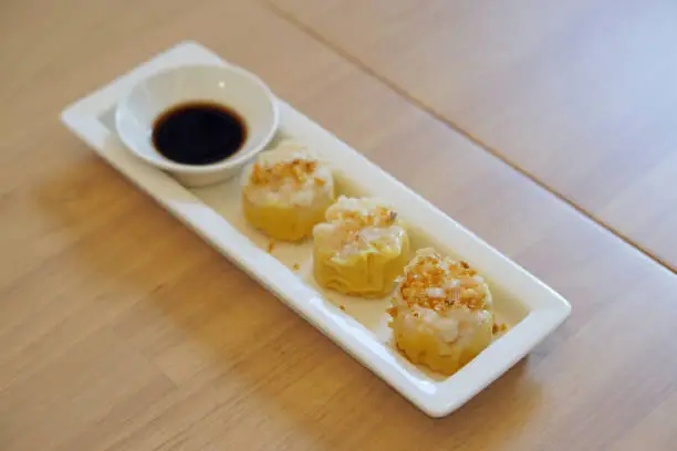 Photo of Dim Sum Recipe - Chinese shrimp dumplings topped with fried garlic, served with sour sauce.