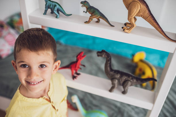 istock Boy playing with toy dinosaurs 1192821293