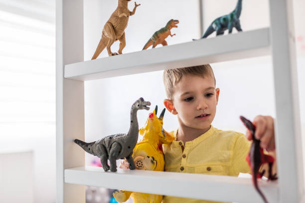 istock Boy playing with toy dinosaurs 1192821889