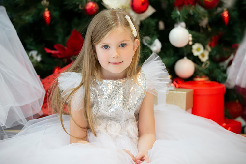 Beautiful little girl in a white dress in Christmas