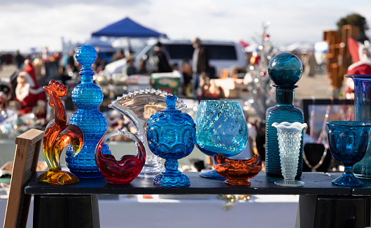 Stand with colorful vintage glass at flea market.