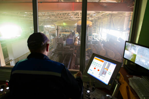 Wood processing plant.Wood processing industry. Wood cutting shop. Worker at the computer controls the cutting of wood