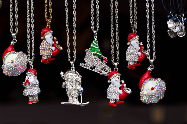 Close up color image depicting a collection of handmade silver Christmas decorations hanging in a row at an outdoor Christmas market. Room for copy space.