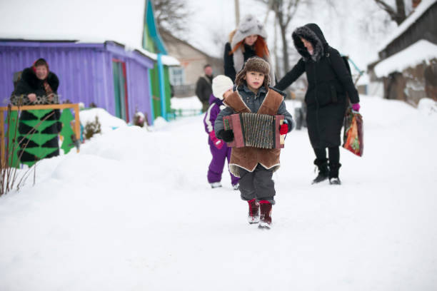 cerimonia kalyada. un bambino del villaggio con una fisarmonica russa cammina lungo una strada invernale - russian culture russia child people foto e immagini stock