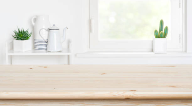 istock Table top in front of defocused window and kitchen shelves 1192831224