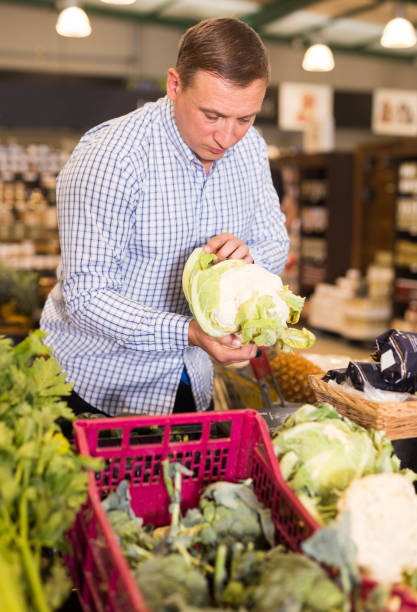 istock Man choosing cauliflower in supermarket 1192835188
