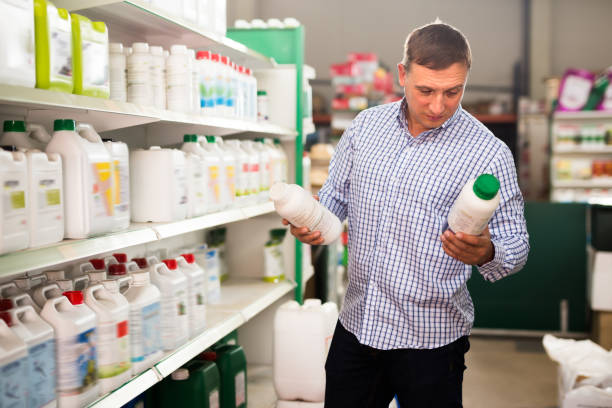 Fine man buying liquid fertilizer for gardening Fine man buying liquid fertilizer for gardening in hypermarket slavic culture photos stock pictures, royalty-free photos & images