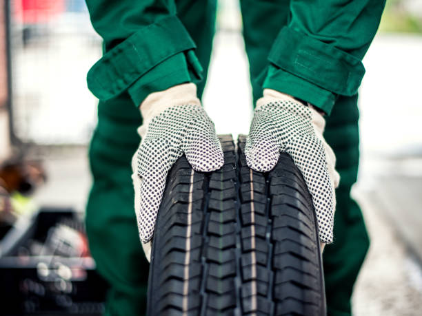 istock Mechanic hands pushing the tire 1192835495