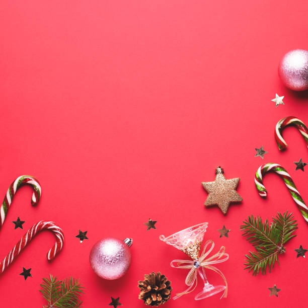 istock Christmas baubles, golden decorations, candy canes, pine tree, cones and confetti frame on red background. Festive Christmas border with golden elements. Flat lay, top view, copy space 1192835620
