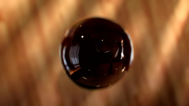 Super slow motion drops of coffee are falling into Cup