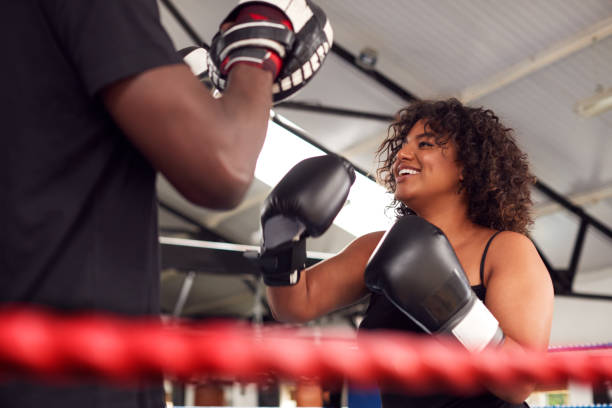 istock Male Personal Trainer Sparring With Female Boxer In Gym Using Training Gloves 1192836641