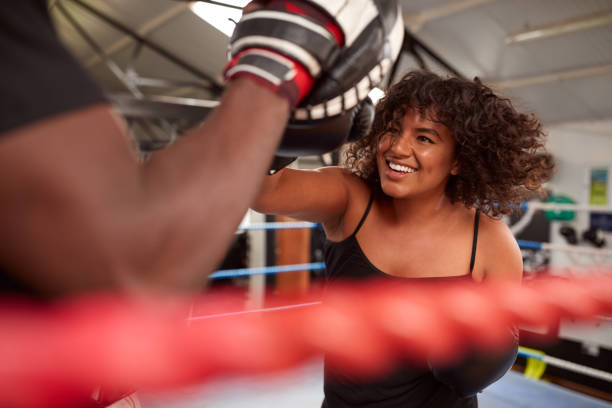 istock Male Personal Trainer Sparring With Female Boxer In Gym Using Training Gloves 1192836715