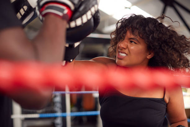 istock Male Personal Trainer Sparring With Female Boxer In Gym Using Training Gloves 1192836716