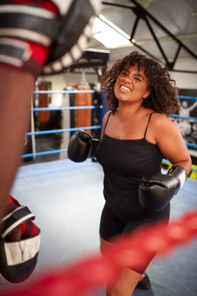 istock Male Personal Trainer Sparring With Female Boxer In Gym Using Training Gloves 1192836799