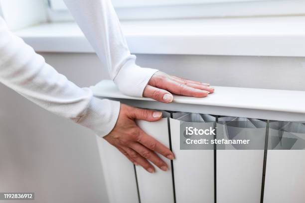 Heavy Duty Radiator Central Heating Woman Is Getting Her Hands Warm On Home Central Heating System Stock Photo - Download Image Now