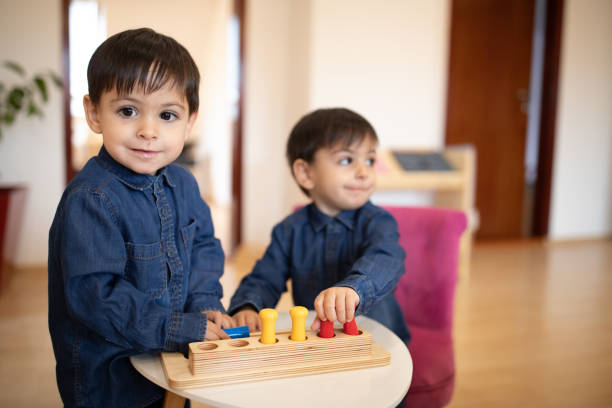 istock Cute twin boys playing  in preschool classroom 1192837763