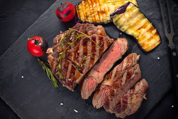 istock Juicy medium rare beef steak on ceramic board with herbs spices and salt 1192837994