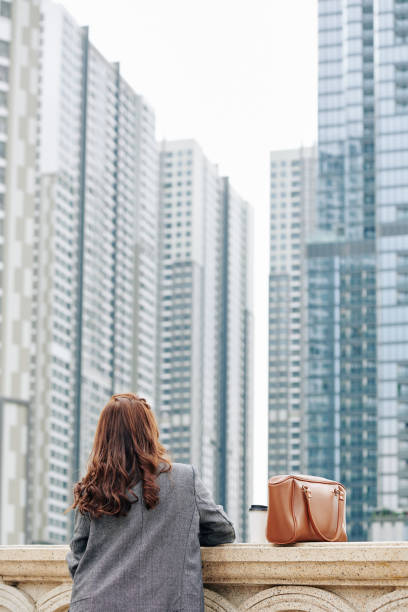 istock Woman looking at high buildings 1192838567