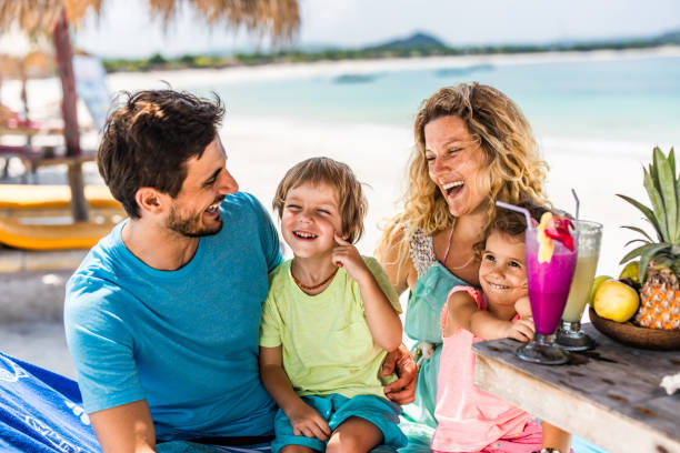 istock Happy parents communicating with their kids in a beach cafe. 1192838832