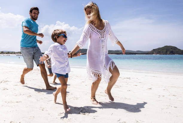 istock Playful family having fun while chasing on the beach. 1192839215