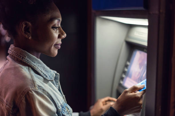istock Woman using her bank card at the ATM device 1192840124