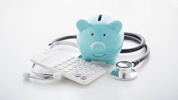 istock Piggy bank with stethoscope and calculator on white table 1192840216