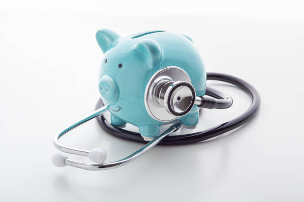 istock Piggy bank with stethoscope on white table 1192840502