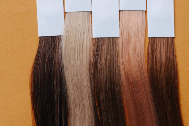 istock Close up image of dyed hair locks. Samples in a row over orange. 1192840877