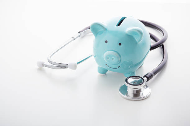 istock Piggy bank with stethoscope on white table 1192841489