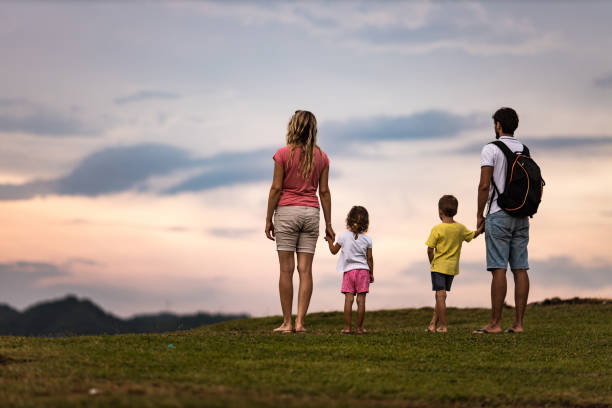 istock Back view of a family looking at view from a hill. 1192842019
