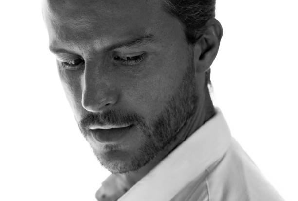 A confident young man in a white shirt