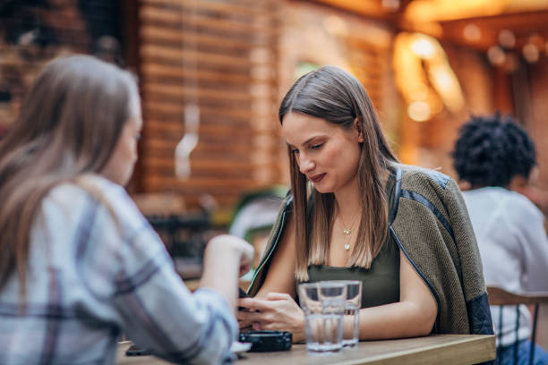 istock Two women sitting outdoors in cafe 1192843337
