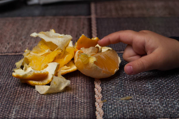 istock Orange on the table.Child holding a fruit. 1192843543